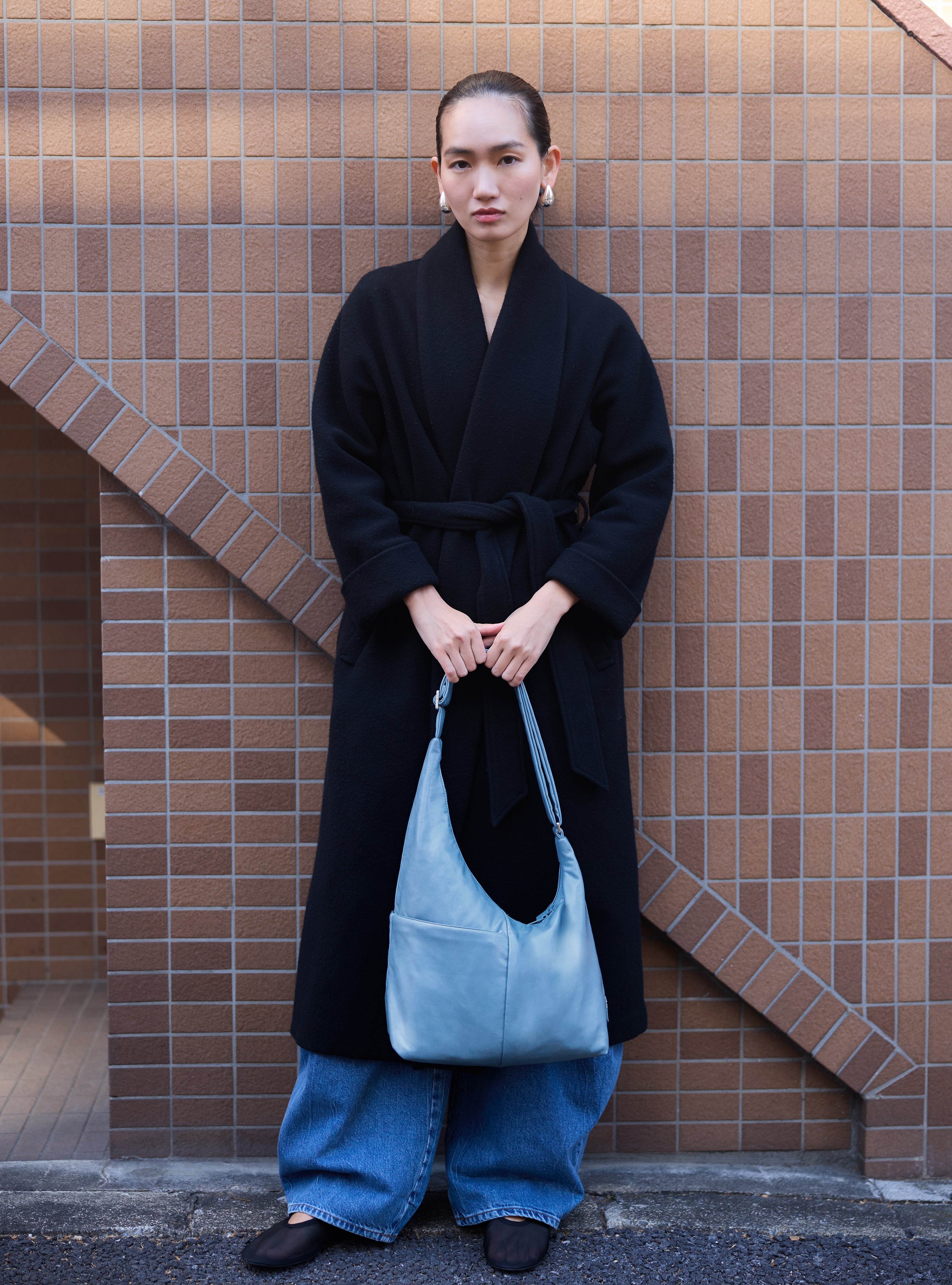 Woman holding the Midi Arc slouchy hobo bag in island blue vegan leather