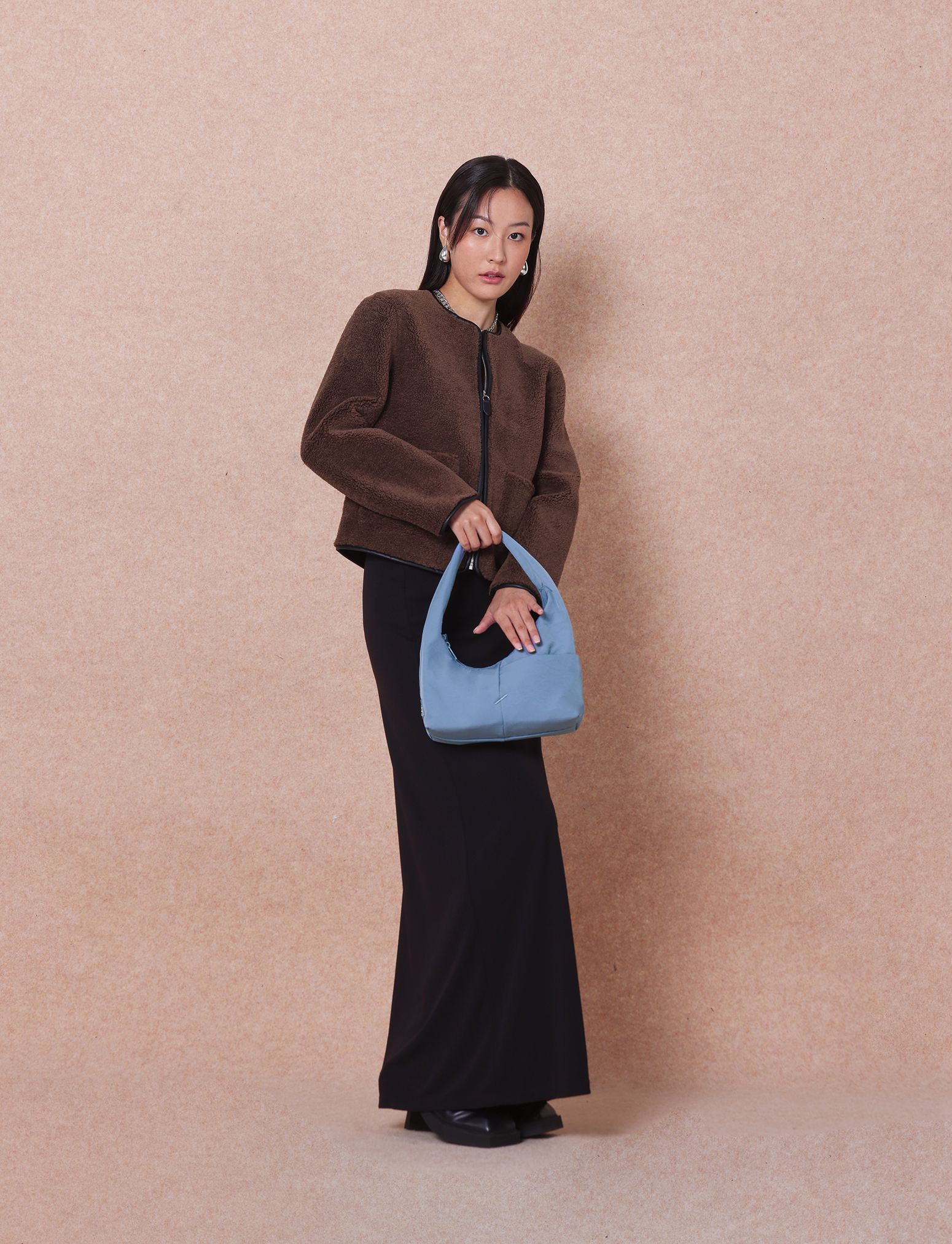 Woman holding the Mini Arc slouchy hobo-style shoulder bag in grey blue nylon for errands, weekends and everyday use