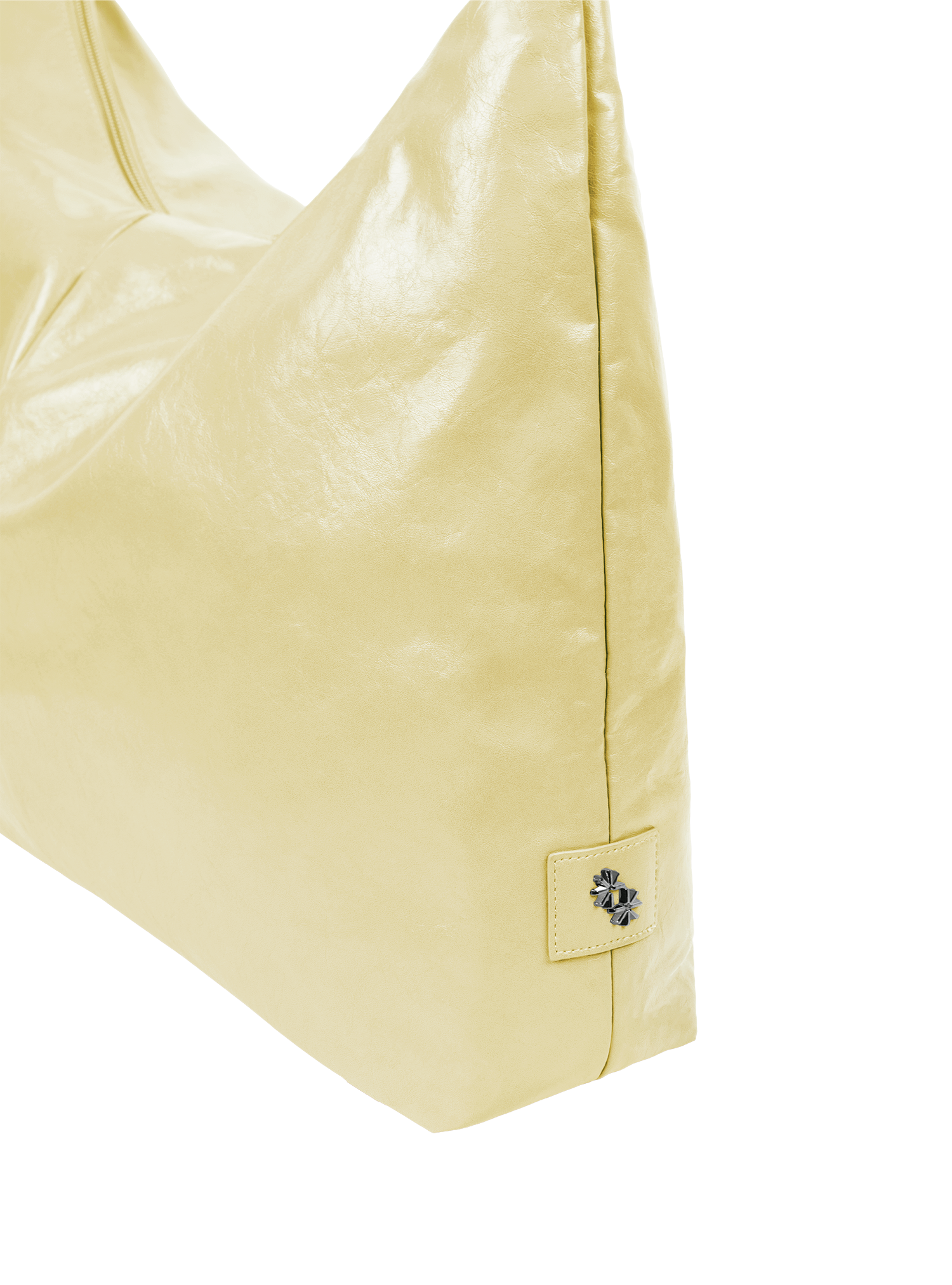 Close-up of the Arc hobo-style bag in pale yellow vegan leather, showing metal logo emblem