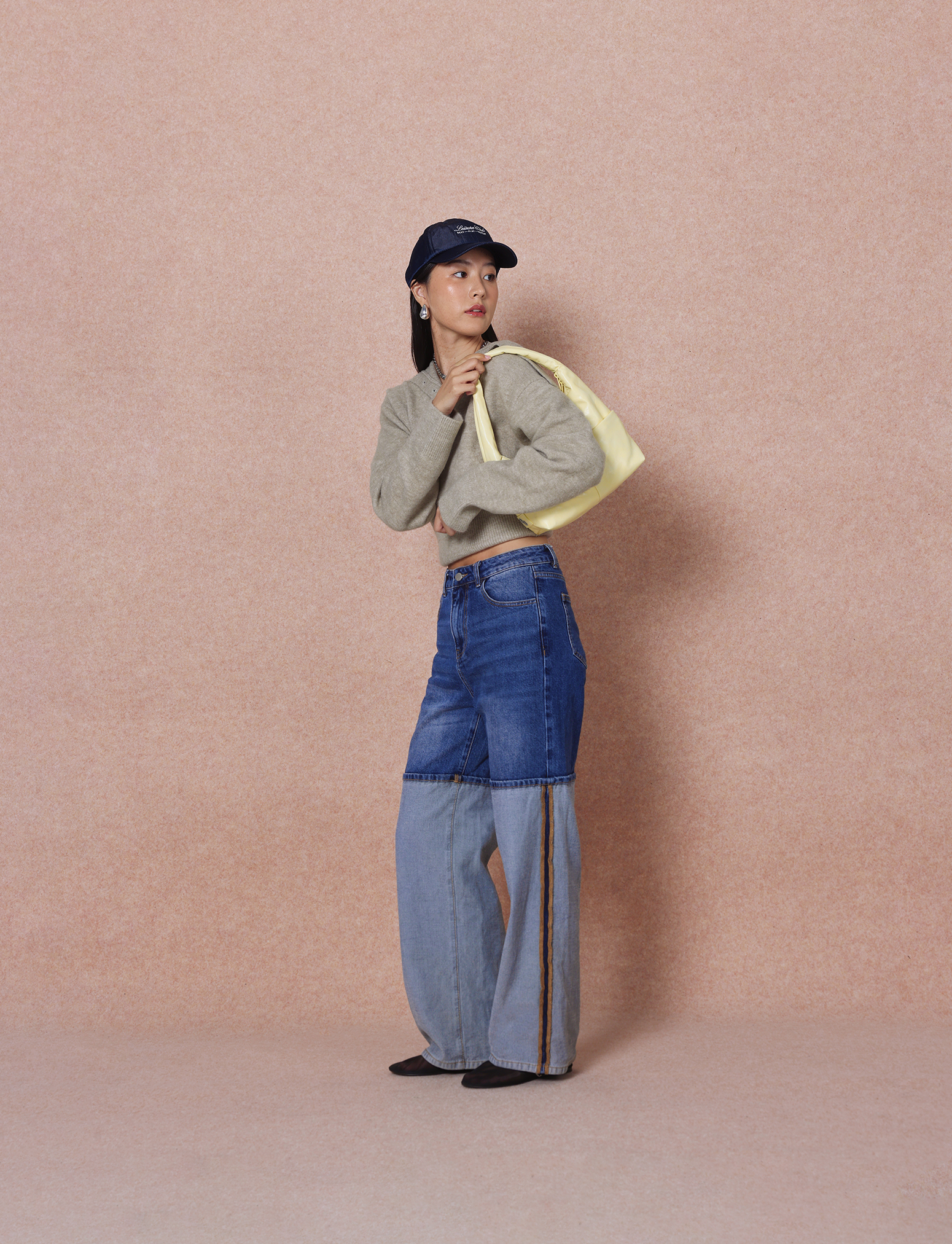 Woman carrying the Mini Arc slouchy hobo shoulder bag in creamy yellow vegan leather