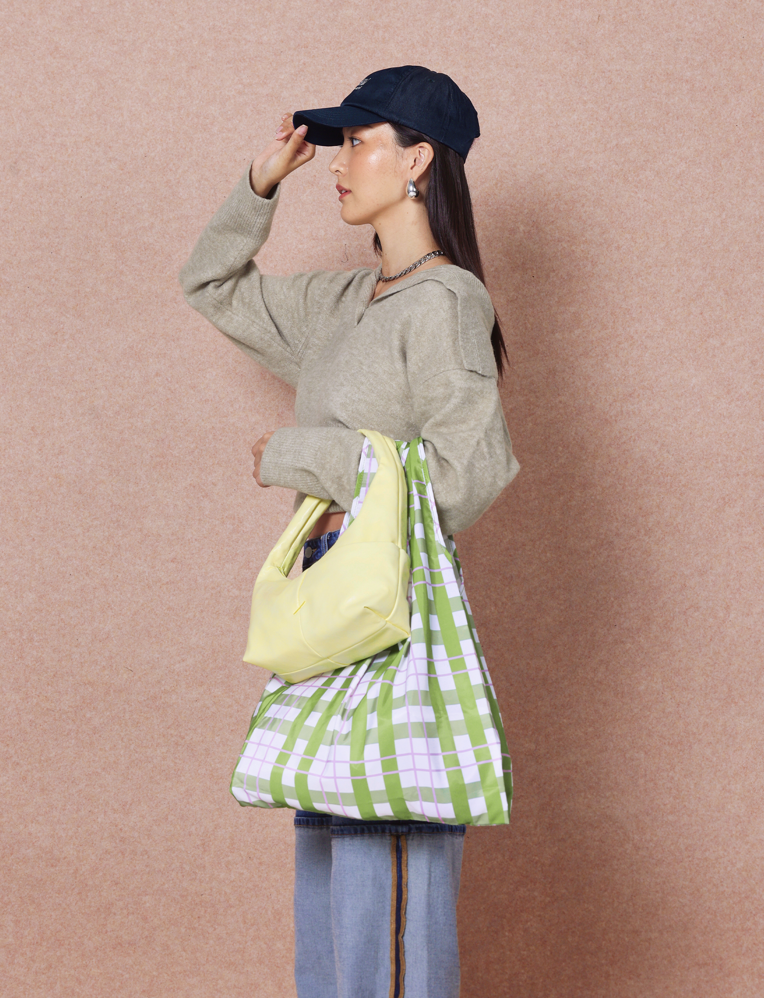 Woman holding the Mini Arc slouchy hobo-style shoulder bag in creamy yellow vegan leather for errands, weekends and everyday use