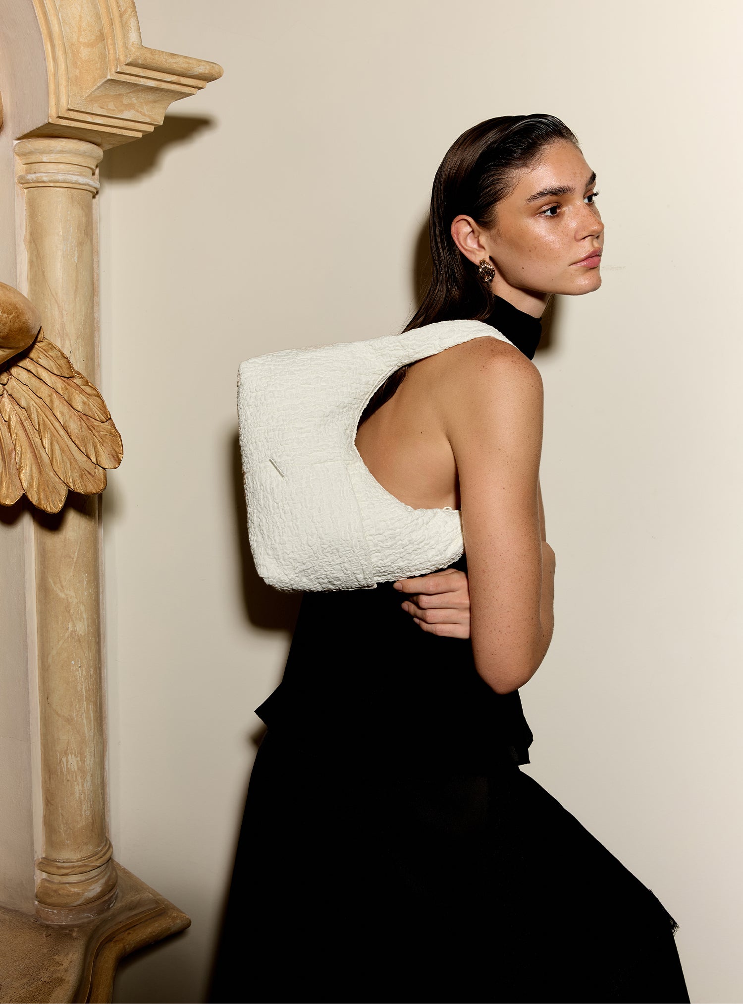 Woman carrying the Mini Arc slouchy hobo shoulder bag in cream polyester-cotton blend