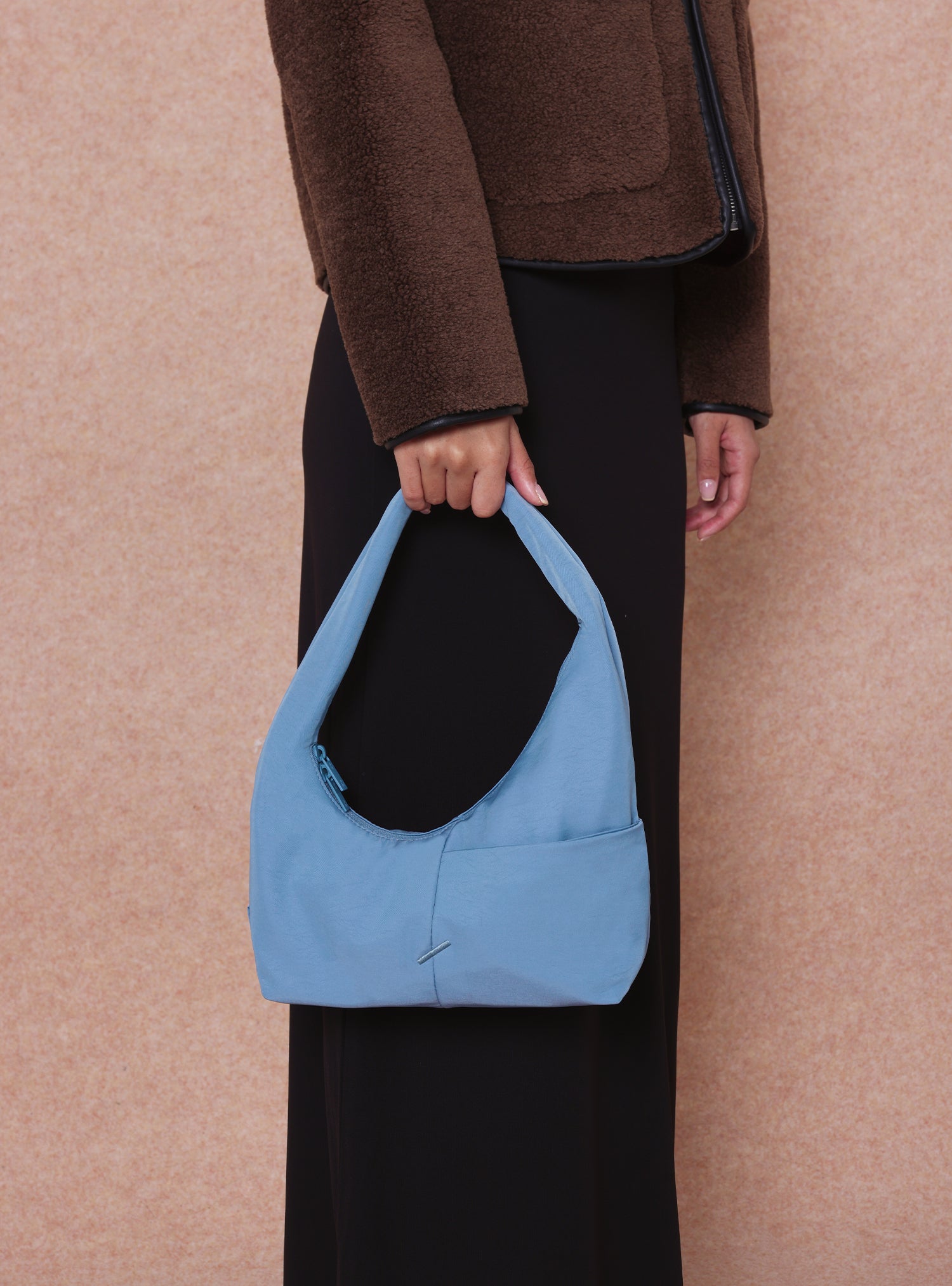 Woman carrying the Mini Arc slouchy hobo shoulder bag in grey blue nylon