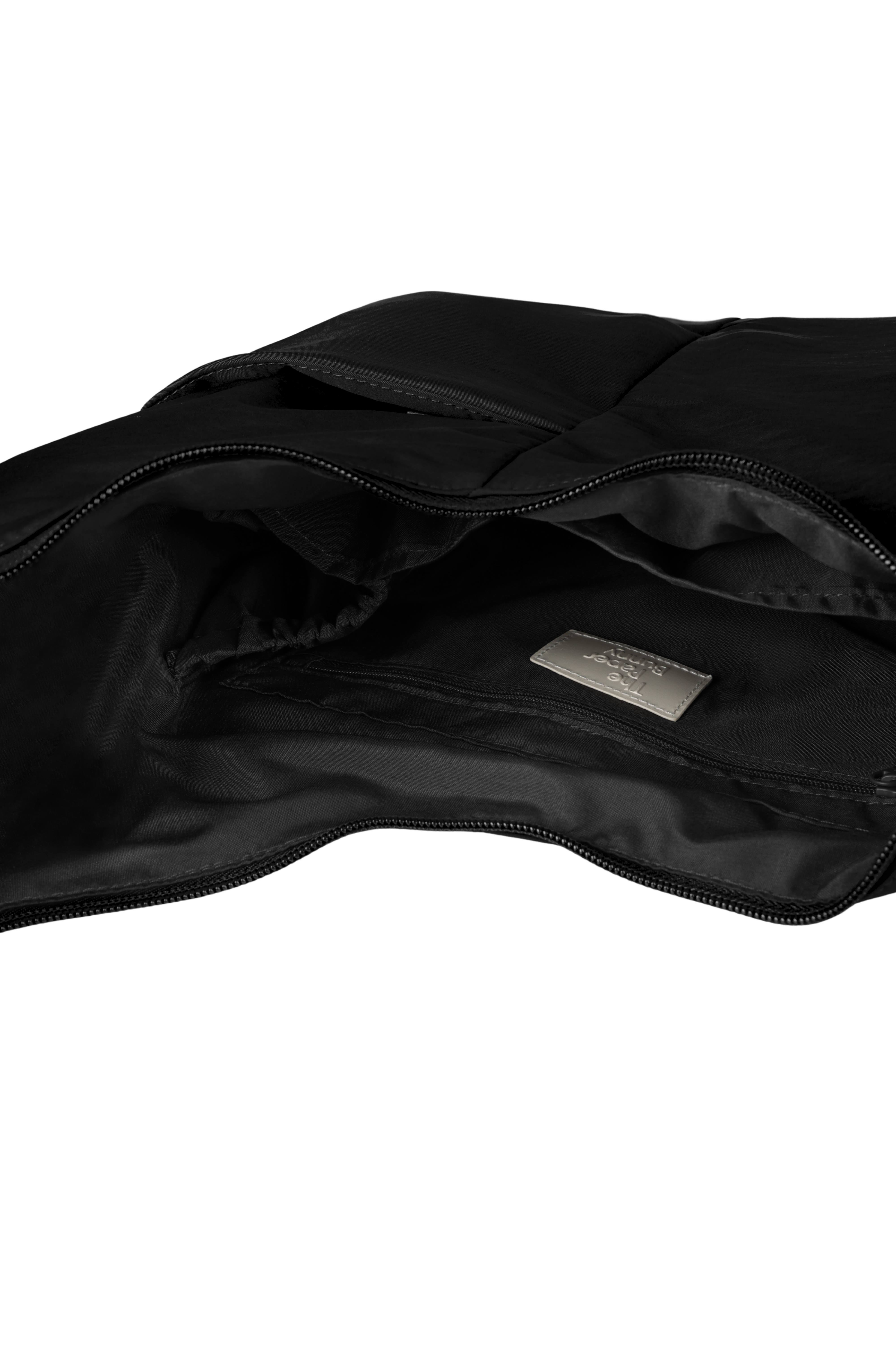 Interior of the Midi Arc hobo-style bag in black nylon, with multiple pockets and a bottle holder