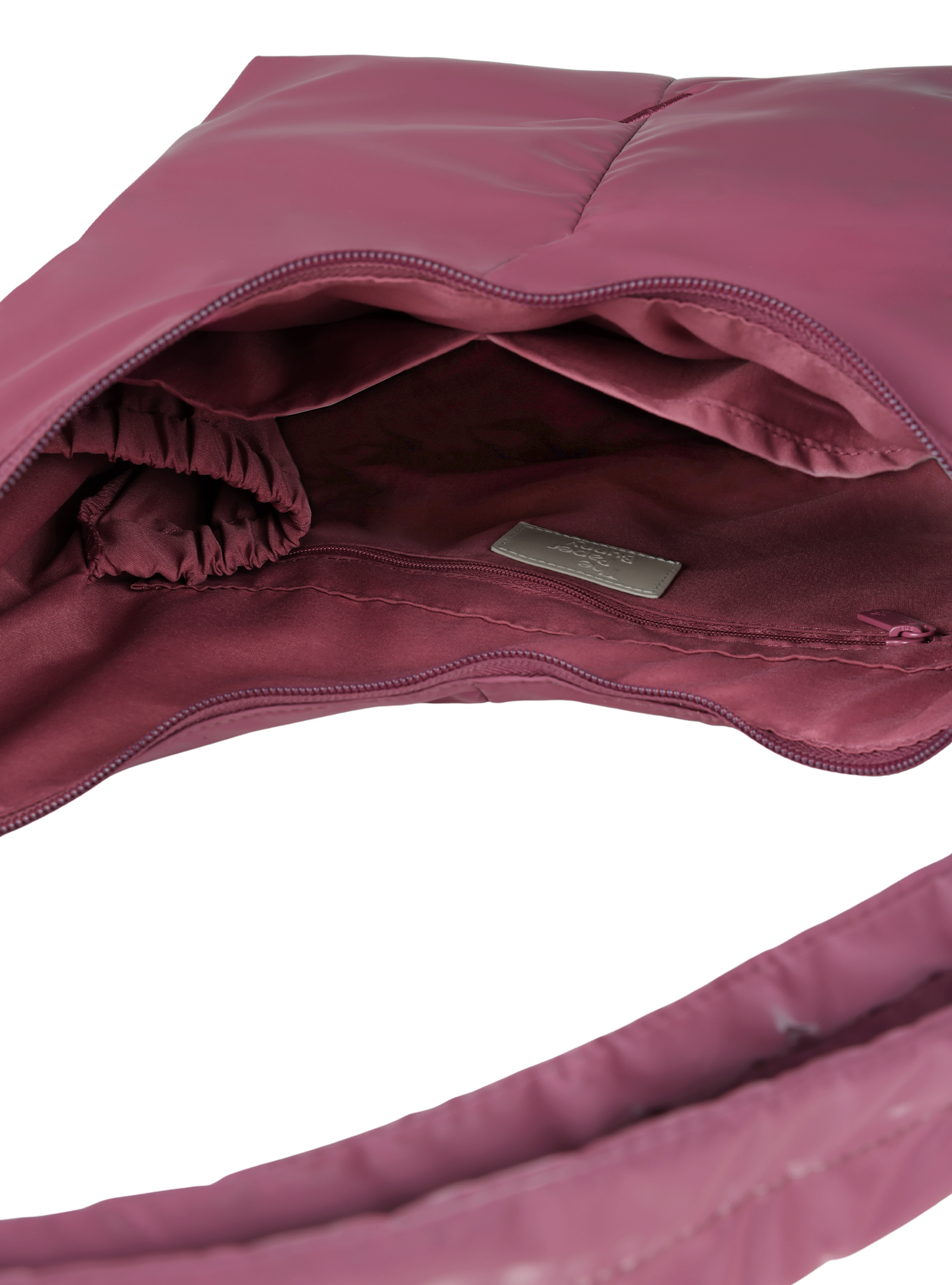 Interior of the Midi Arc hobo-style bag in rouge pink polyester, with multiple pockets and a bottle holder