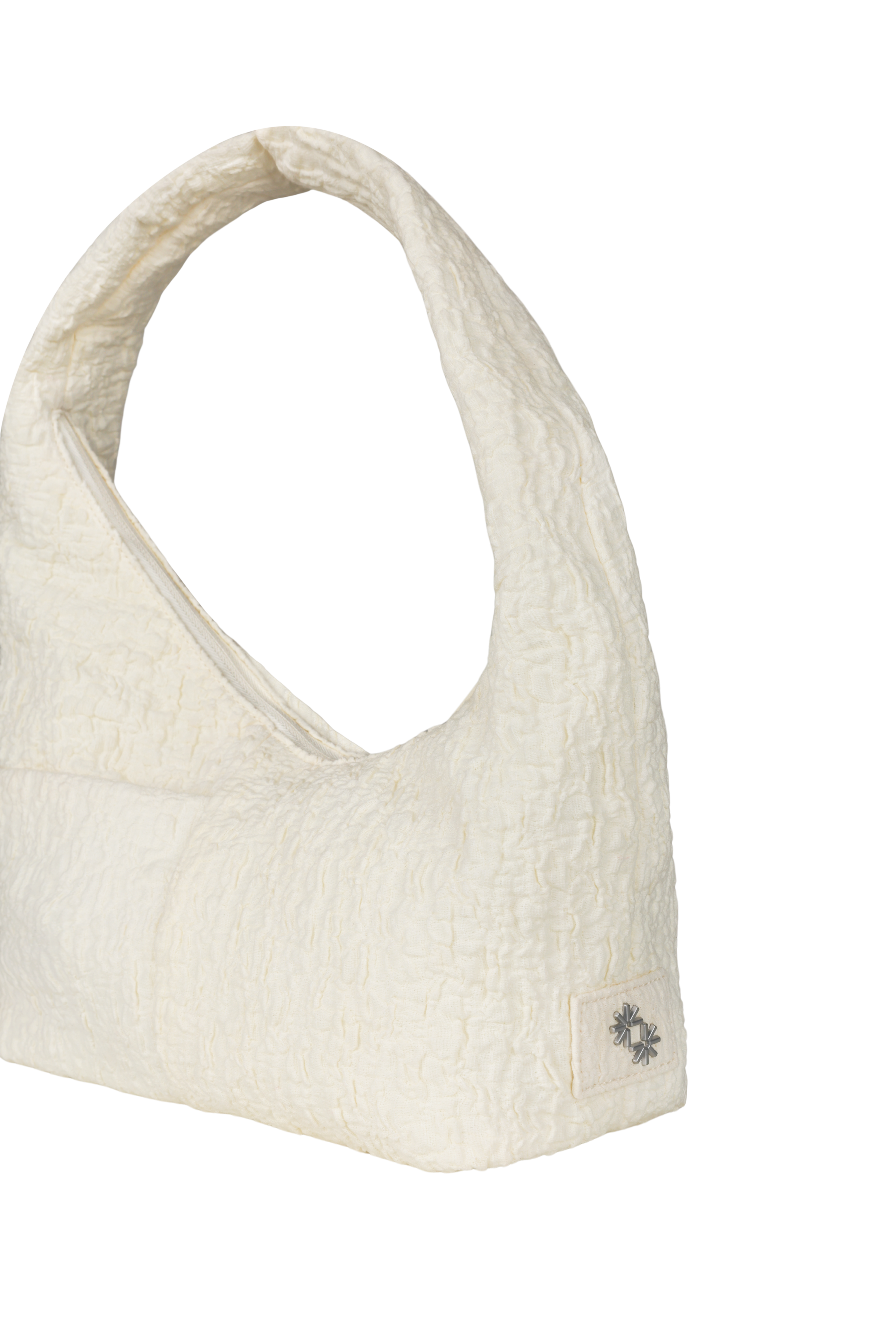 Close-up of the Mini Arc hobo-style shoulder bag in cream polyester-cotton blend, showing metal logo emblem