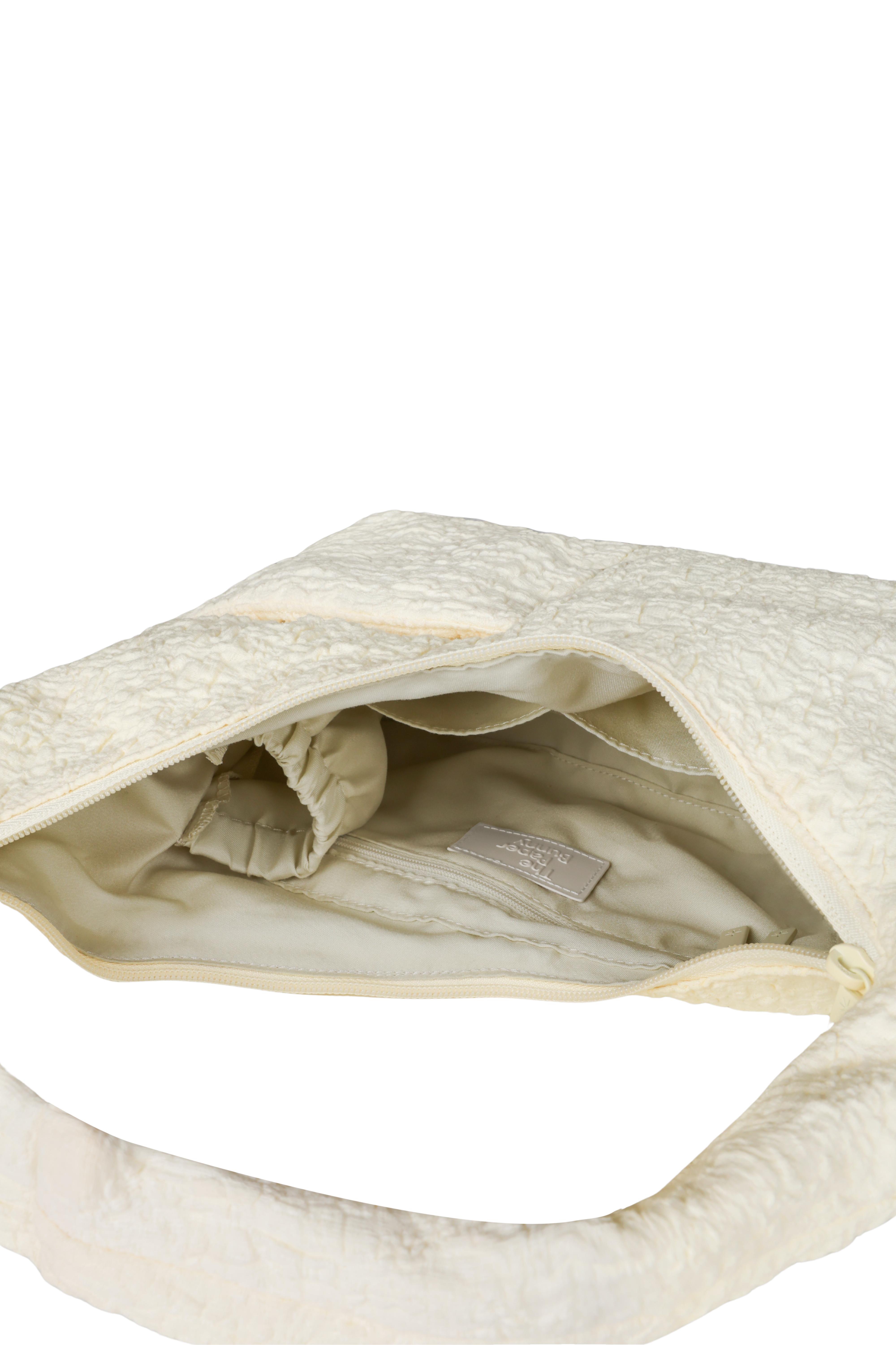 Interior of the Mini Arc hobo-style shoulder bag in cream polyester-cotton blend, with multiple pockets and a bottle holder